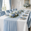 Lyseblå Gaze bordløber fra Servietringen, 300x90 cm, vises på spisebord med elegante kantdetaljer